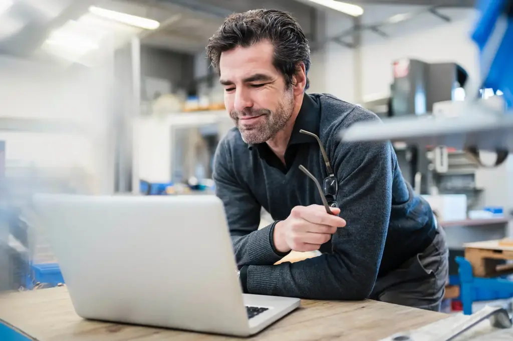Engineer working at a laptop in a workshop