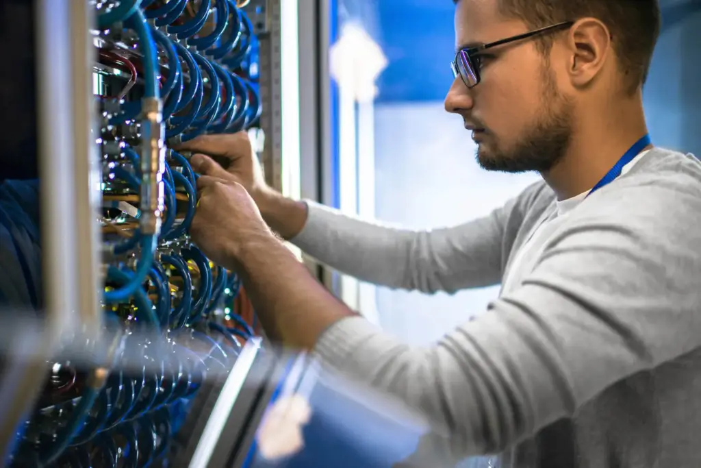 Engineer working on network cabling in a rack