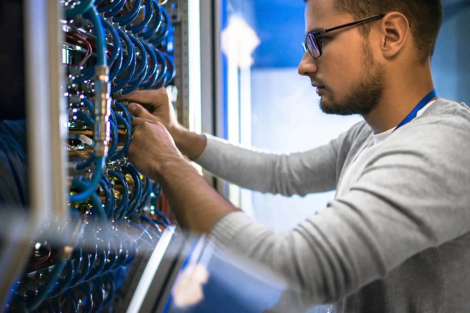 Engineer working on network cabling in a rack