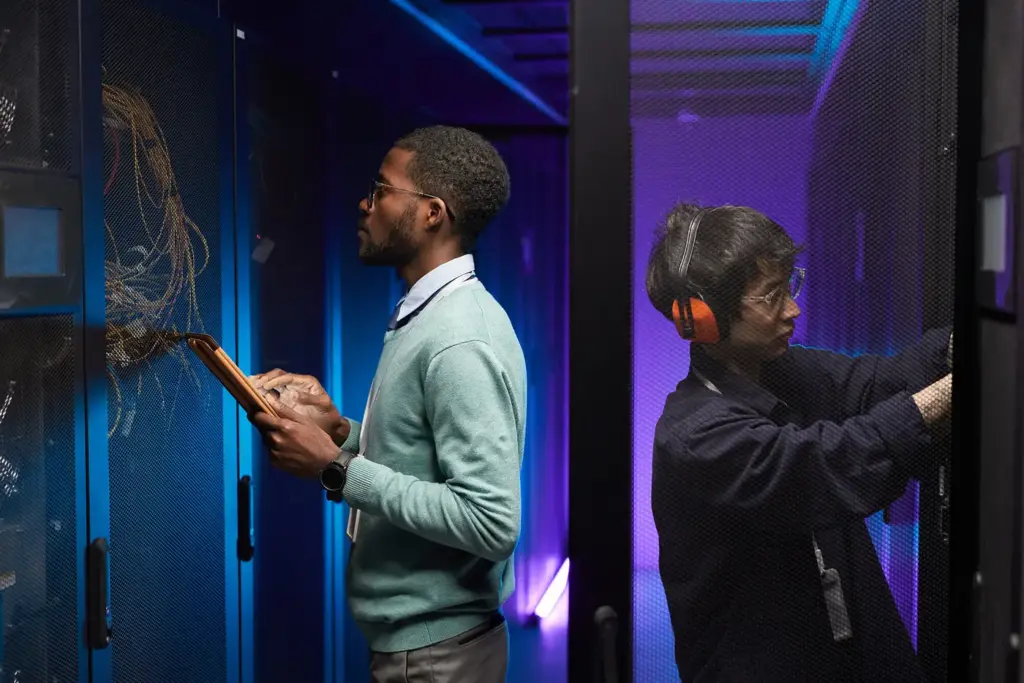 Two engineers working in a server room
