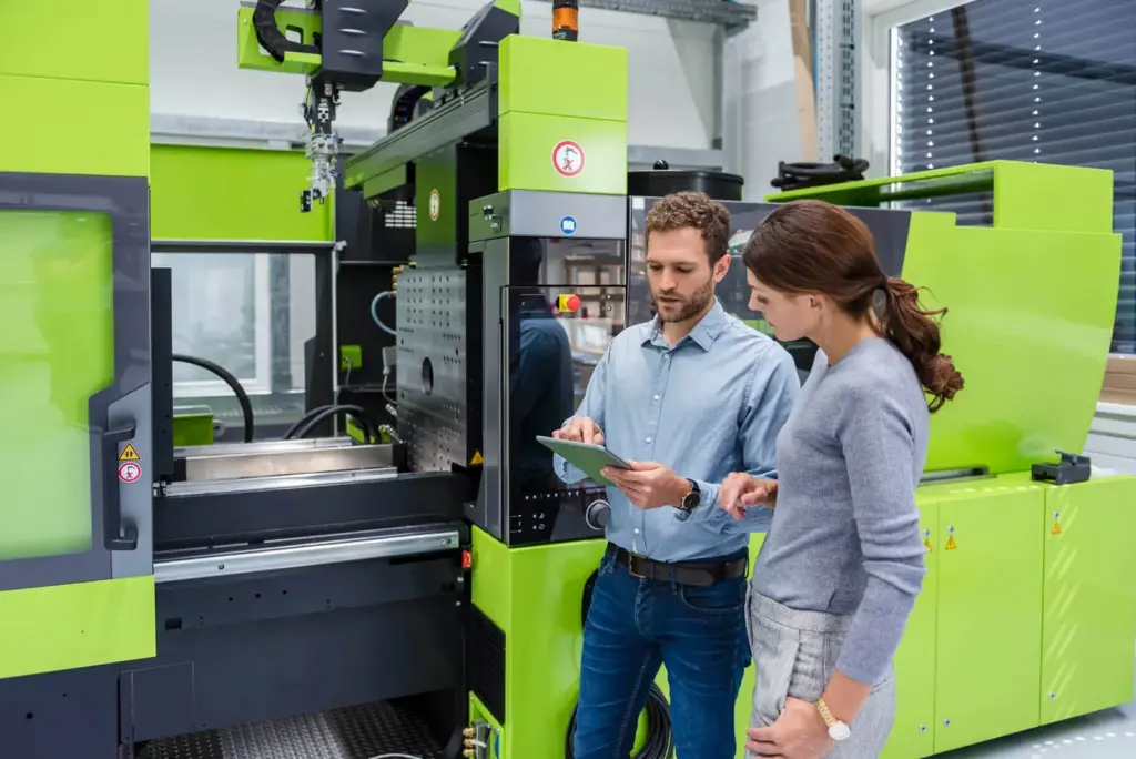 Two engineers reviewing data on a manufacturing floor
