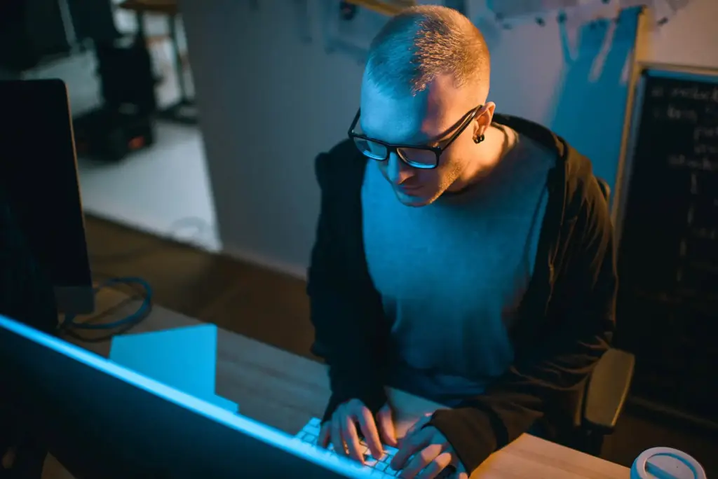 Security engineer working at a workstation in a dark office