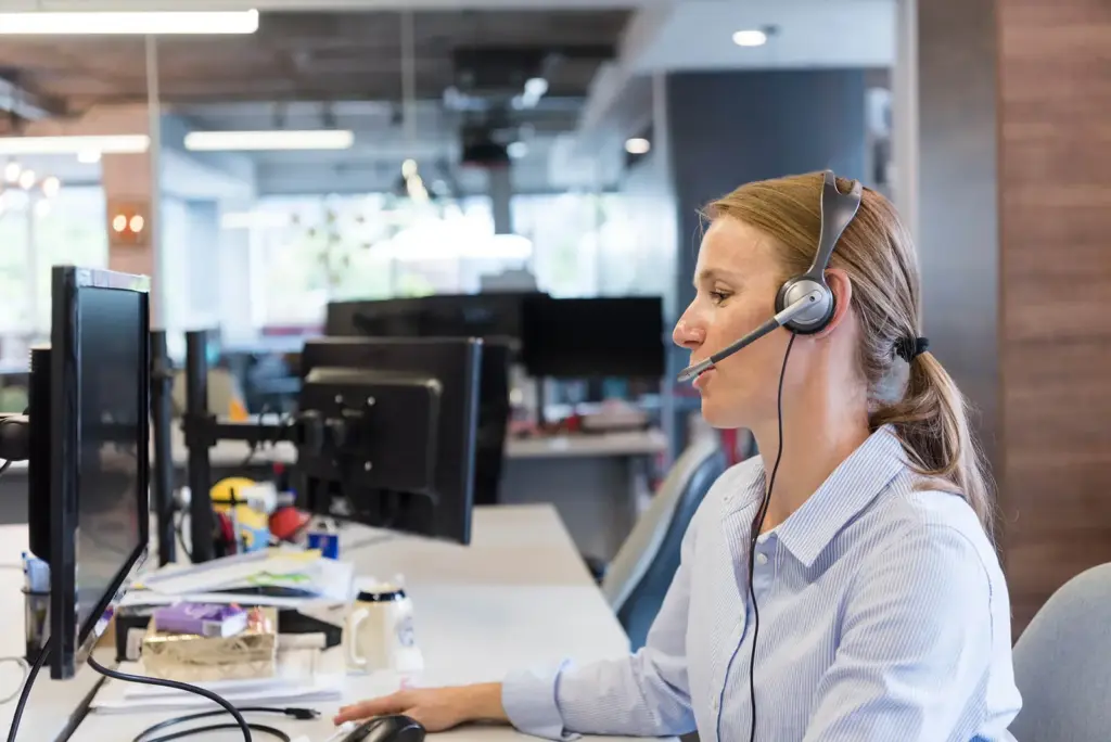 Support engineer with a headset at her desk