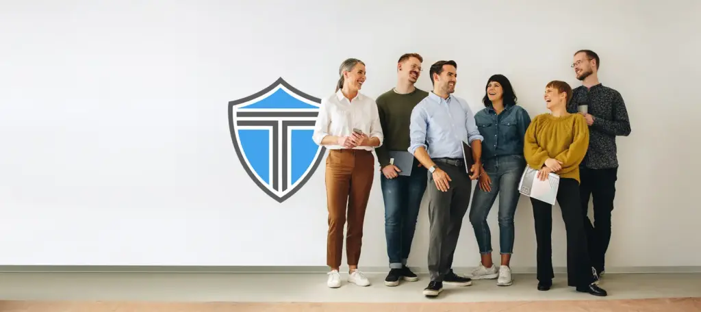 Team standing in front of the Triden shield